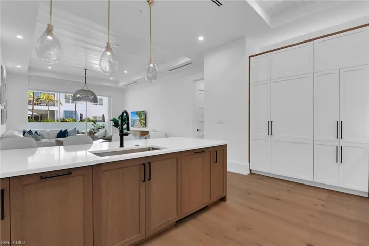 Kitchen featuring a sink, open floor plan, light wood-style floors, light countertops, and recessed lighting