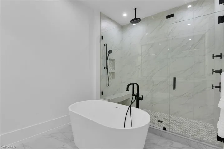 Full bathroom with marble finish flooring, a marble finish shower, a freestanding tub, baseboards, and recessed lighting