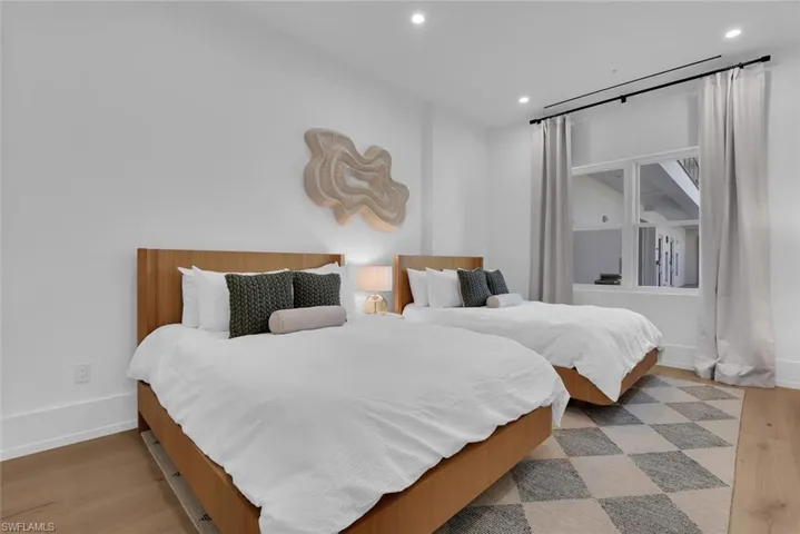 Bedroom with wood finished floors, recessed lighting, and baseboards