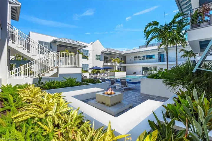 View of home's community with an outdoor fire pit, stairs, a patio area, and a pool