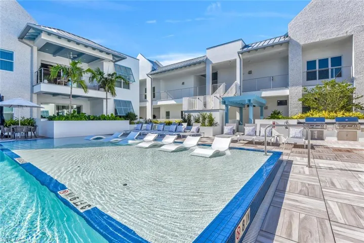 View of pool featuring a grill and an outdoor kitchen