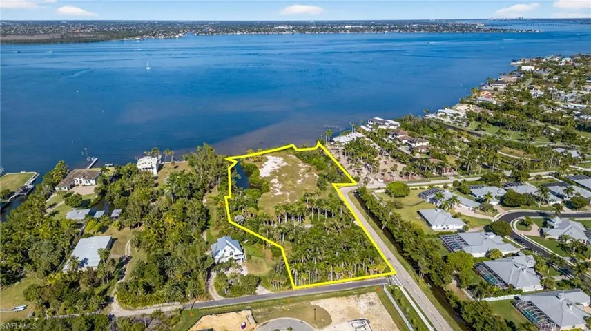 Aerial view of property's location featuring property boundaries highlighted, a large body of water, and nearby suburban area