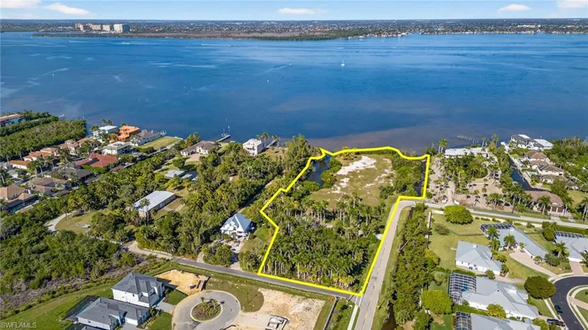 Aerial view of property and surrounding area featuring property parcel outlined and nearby suburban area