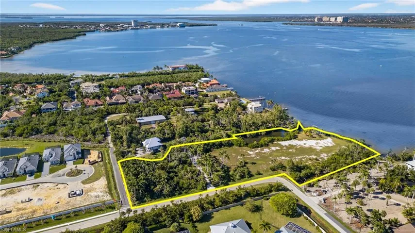 Aerial view of residential area with property parcel outlined and a large body of water