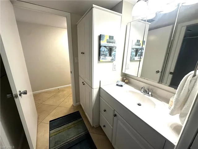 Bathroom featuring a vanity with an integrated sink, a medicine cabinet, and a tall storage cabinet