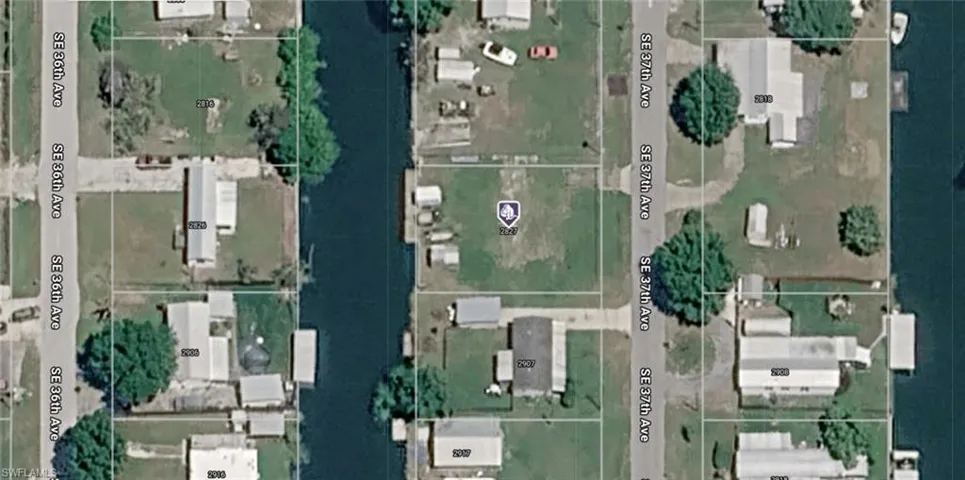 Aerial Survey Map. Depicting the property layout with structures, vegetation, and waterway boundaries in relation to surrounding parcels