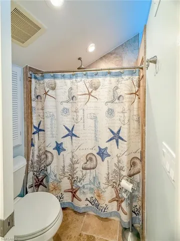 Full bathroom featuring visible vents, toilet, and a shower with curtain
