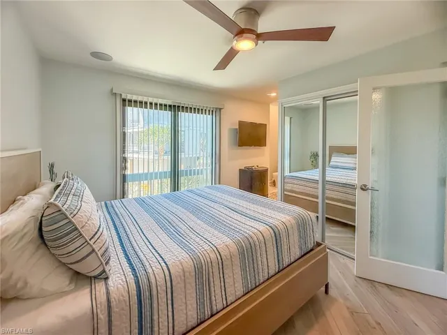 Bedroom with access to exterior, light wood-style flooring, a closet, and ceiling fan
