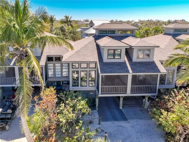 View of front of property with a sunroom and roof with shingles