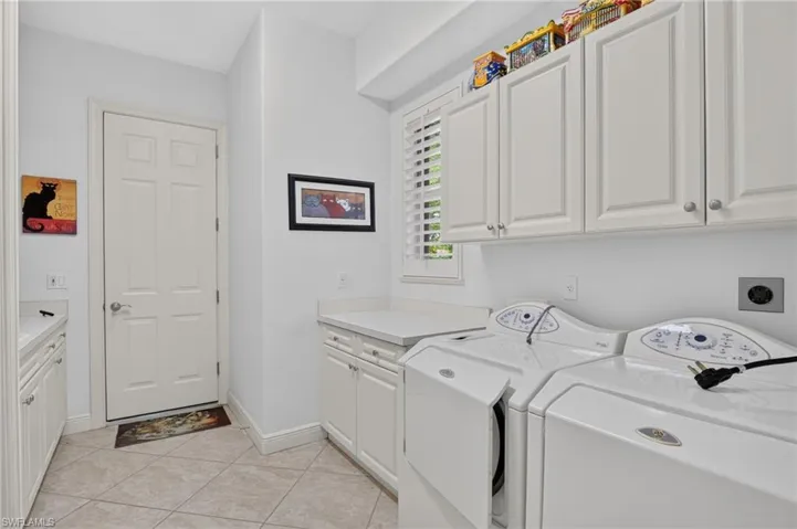 Spacious laundry room with cabinets, folding table and slop sink.