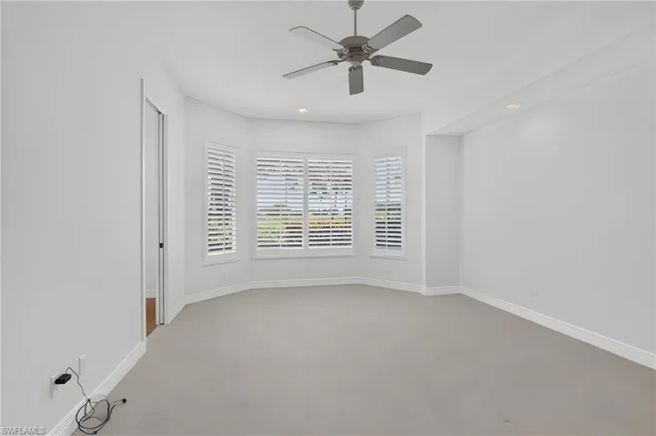 Large primary suite bedroom with golf course view.