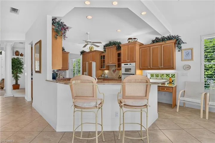Large center island kitchen opens to living area and offers counter seating.