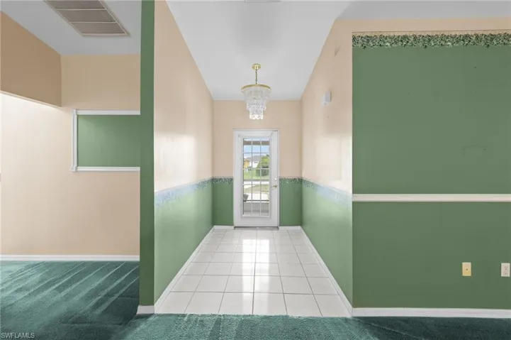 Entryway with a chandelier, baseboards, and tile patterned flooring