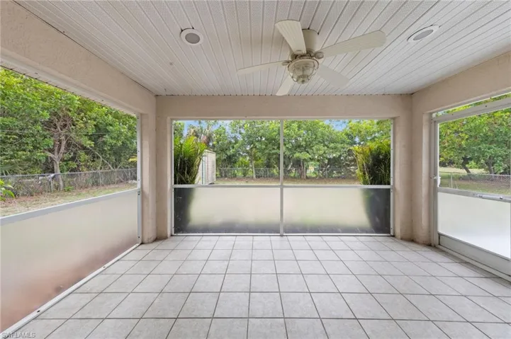 Unfurnished sunroom featuring ceiling fan