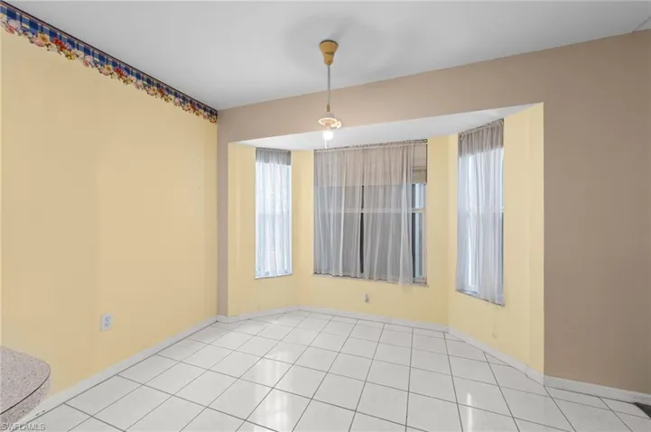 Spare room featuring baseboards and tile patterned flooring