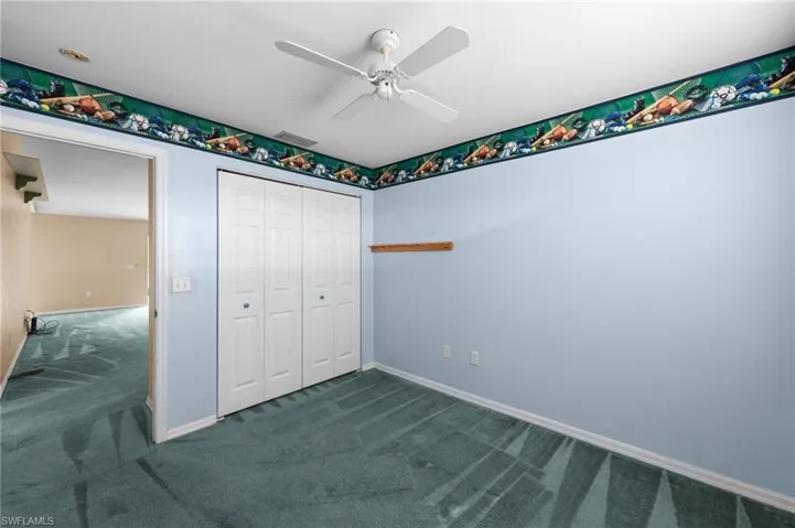 Unfurnished bedroom featuring carpet floors, a closet, baseboards, and ceiling fan