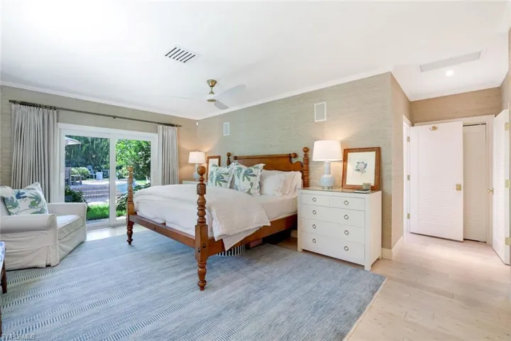 Bedroom with access to outside, light wood-type flooring, crown molding, a ceiling fan, and wallpapered walls