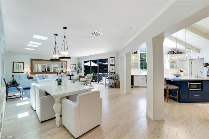 Dining room featuring a chandelier, light wood finished floors, ornamental molding, and beverage cooler