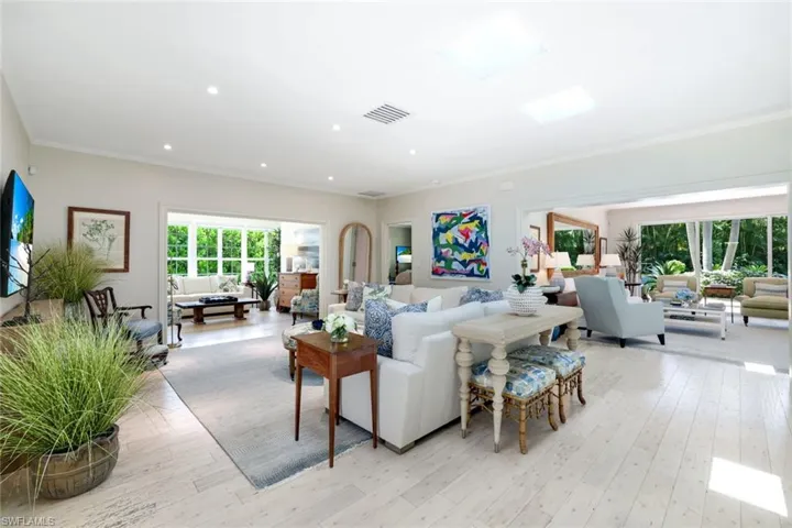 Living area featuring crown molding, light wood-type flooring, plenty of natural light, and recessed lighting
