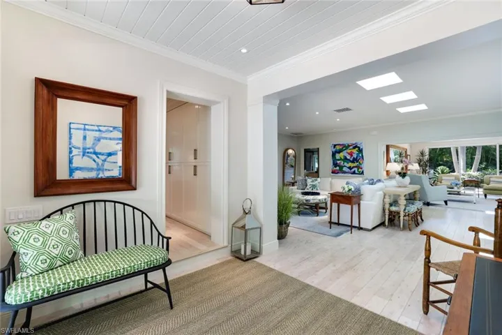 Living area featuring ornamental molding and light wood-type flooring