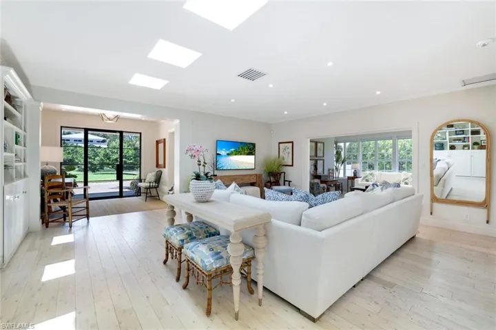 Living area with light wood-style floors, ornamental molding, and recessed lighting