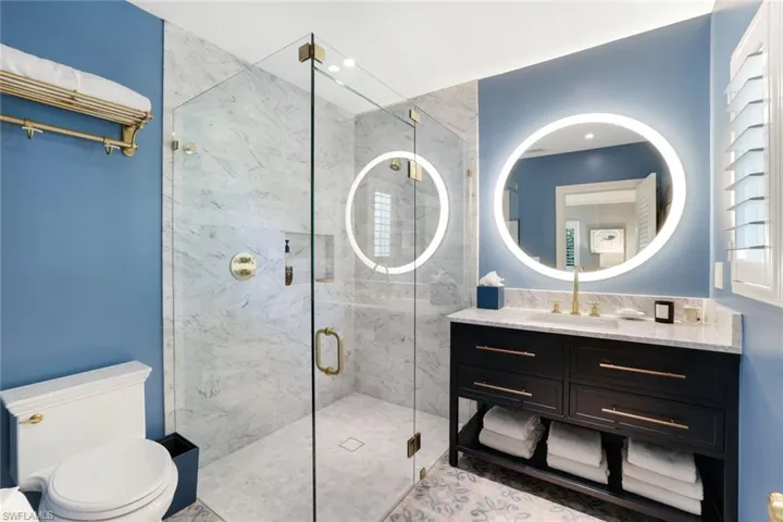 Full bath with vanity, a marble finish shower, and recessed lighting
