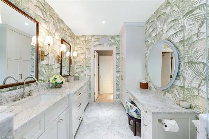 Full bath featuring wallpapered walls, double vanity, recessed lighting, and light marble finish flooring