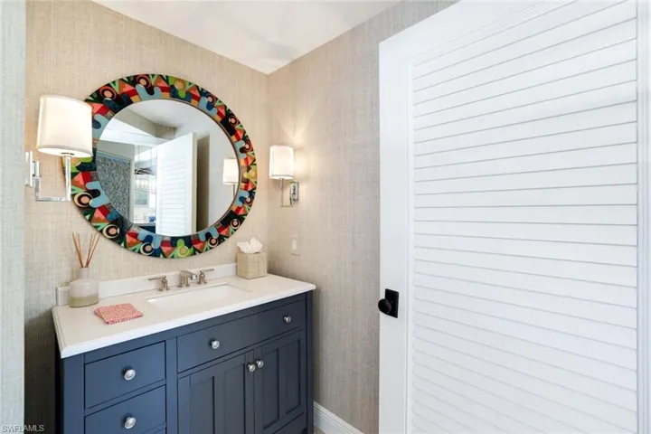 Bathroom with vanity and wallpapered walls