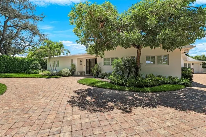View of front of house with stucco siding and decorative driveway