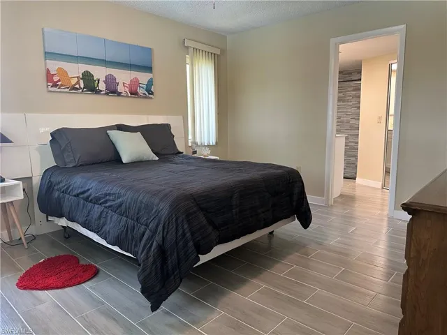 Bedroom featuring wood-finish tile flooring and neutral wall tones