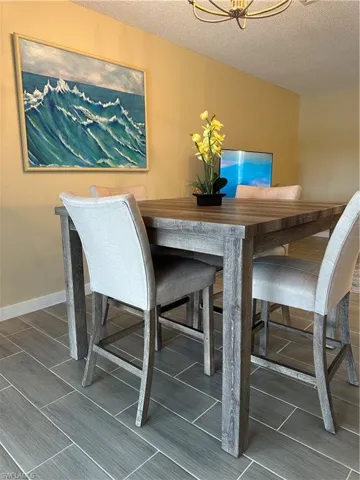 Dining area featuring contemporary wood-finish flooring, a light amber wall color, and a modern ceiling fixture
