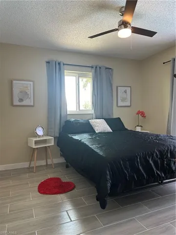 Interior space featuring wood-finish tile flooring and a ceiling fan with integrated lighting
