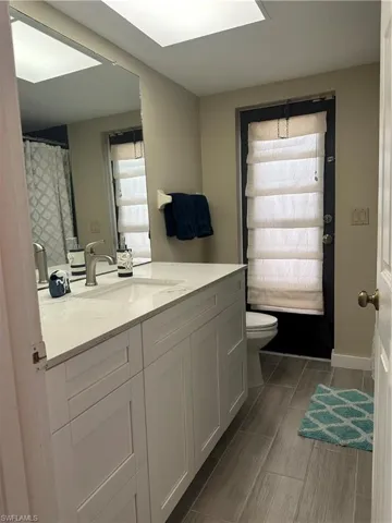 Modern vanity featuring white cabinetry, a light-toned countertop, and an integrated sink