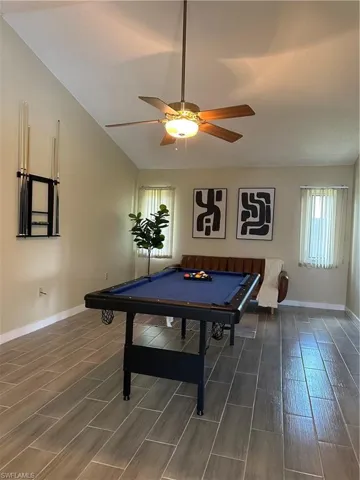 Room featuring high vaulted ceilings, wood-finish flooring, and recessed lighting