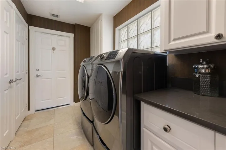 15339 Upwind Dr Bonita Springs FL 34135 - Laundry room with lots of cabinets, overflow pantry area, and utility sink.