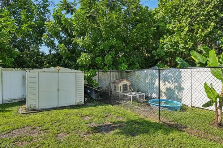 Fenced backyard featuring a storage shed