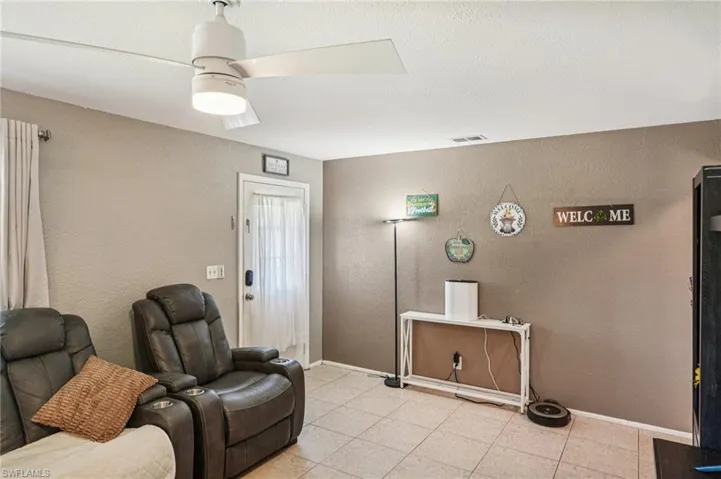Sitting room featuring a textured wall, light tile patterned floors, and a textured ceiling