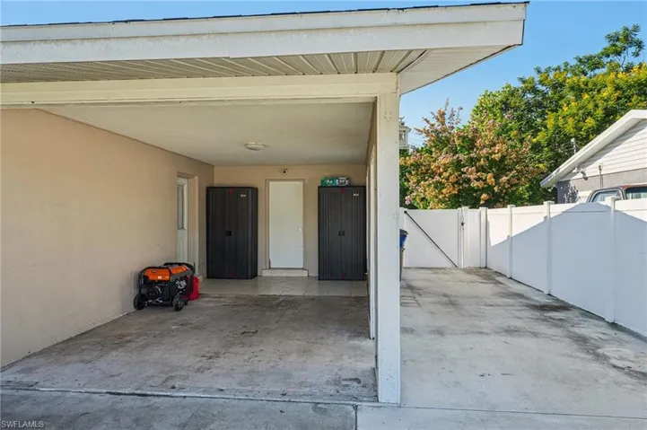 View of exterior entry with a gate, a patio area, stucco siding, and a carport