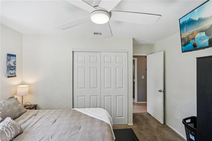 Bedroom featuring ceiling fan, carpet floors, and a closet