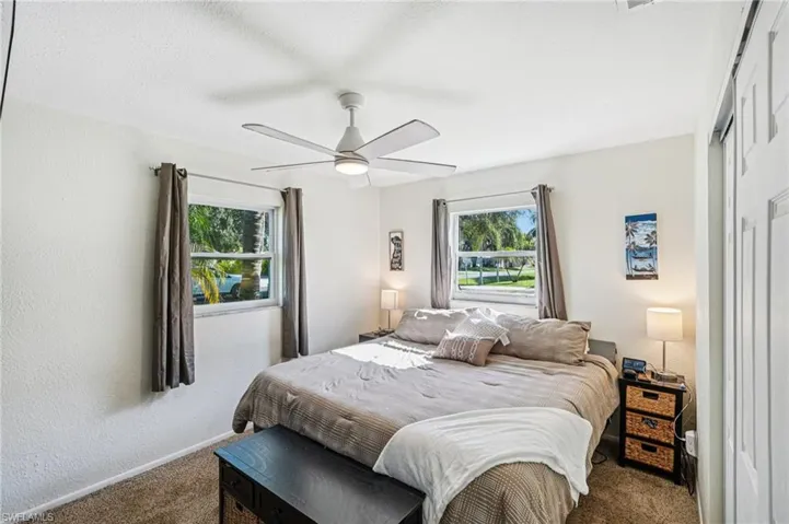 Bedroom with a textured wall, a ceiling fan, carpet floors, and a textured ceiling