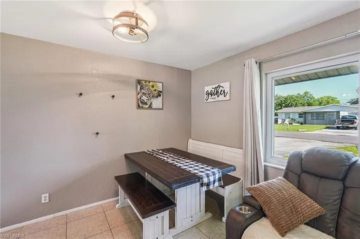 Living area with a textured wall and tile patterned flooring