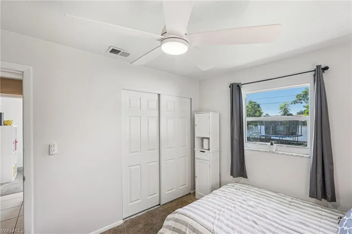 Bedroom featuring carpet, a ceiling fan, and a closet