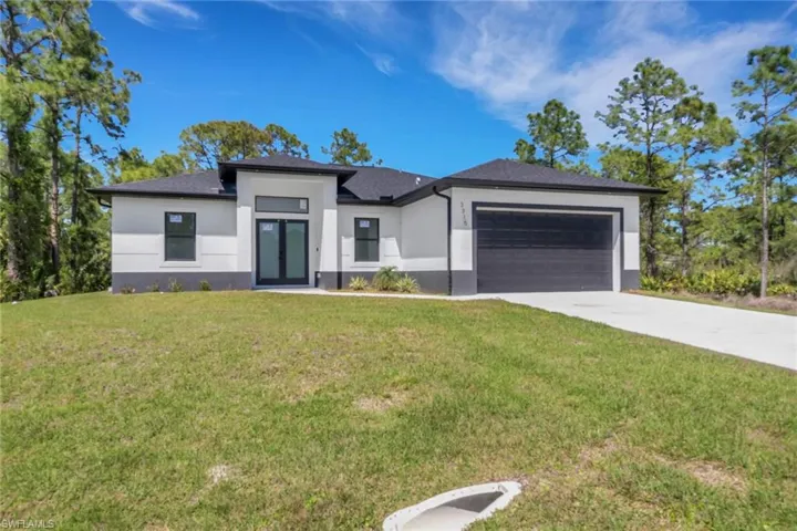 Prairie-style house with an attached garage, driveway, stucco siding, and a front lawn
