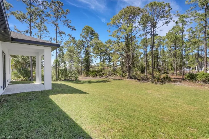 View of grassy yard with a patio
