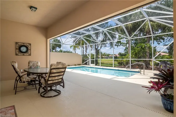 View of pool with a lanai and a shaded patio area