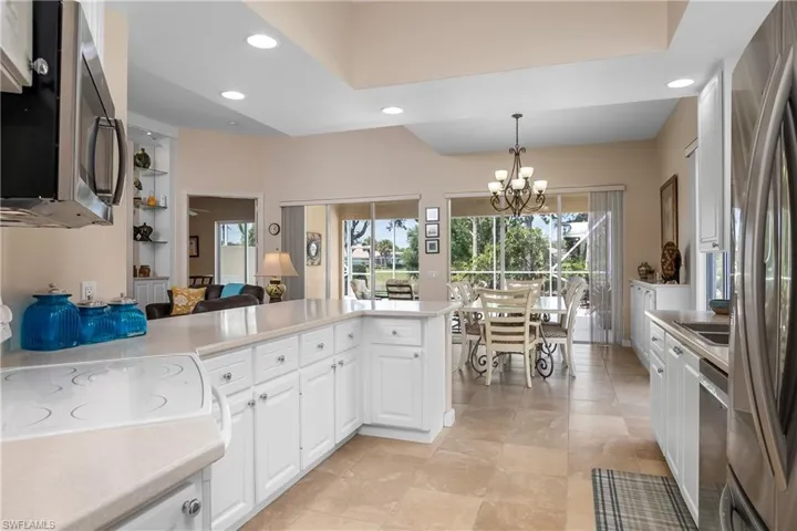 Kitchen with white cabinets, a wealth of natural light, and kitchen peninsula