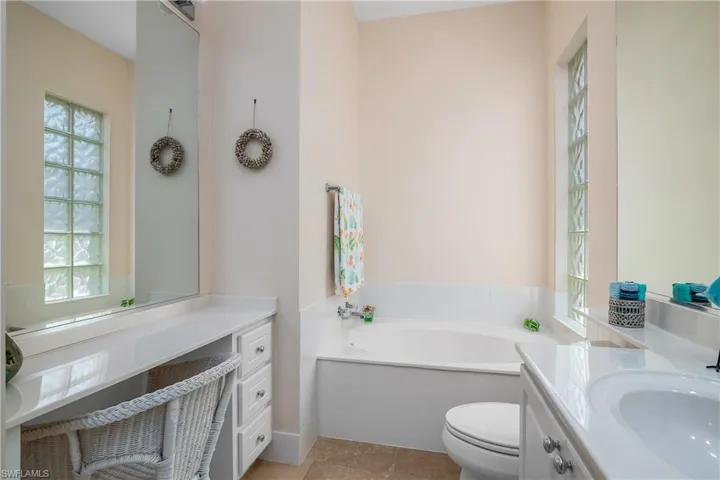 Primary suite Bathroom with toilet, a washtub, vanity, and tile flooring