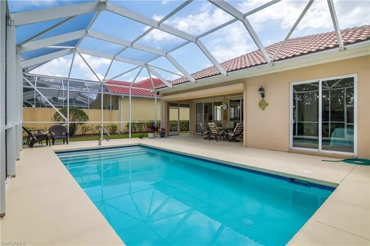 View of swimming pool and patio. Note the neighbor's concrete wall which is similar to this home's wall, affording total privacy