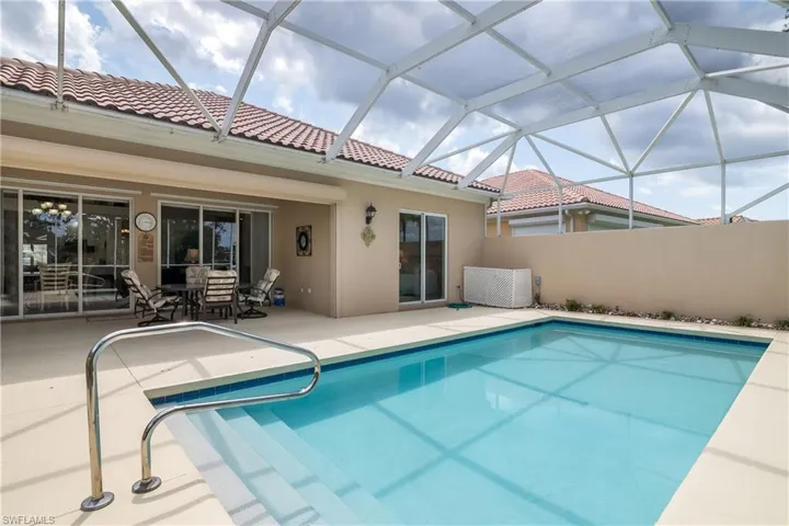 View of swimming pool and patio with enclosure for pool pump