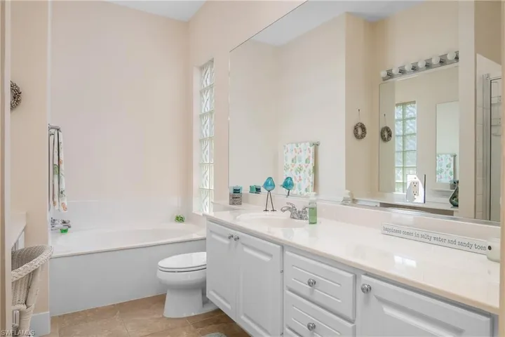 Bathroom with vanity/ extensive cabinet space, washtub, tile flooring. One of two bathroom areas as part of Primary suite